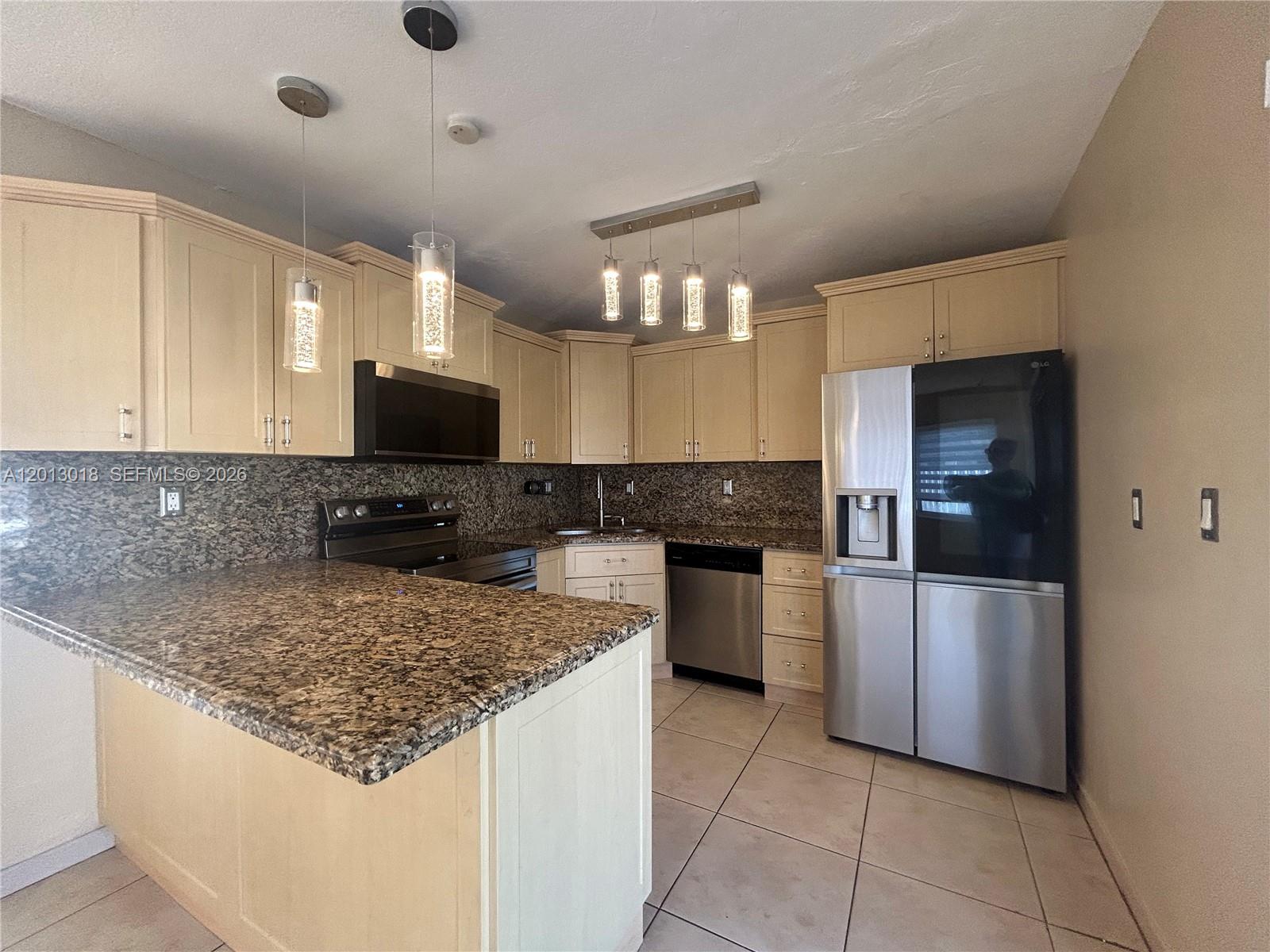 6202 Southwest 107th Avenue Miami, FL 33173 - Photo 8 of 22 a kitchen with a sink a microwave and cabinets