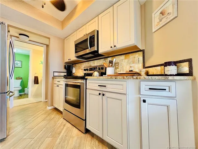 a kitchen with stainless steel appliances granite countertop a stove a sink and a microwave