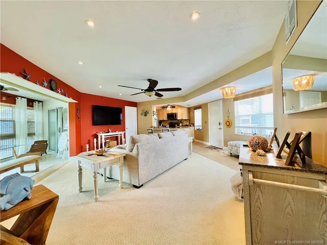 a living room with furniture a flat screen tv and a large window