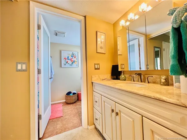 a en suite bathroom with a granite countertop sink and a mirror