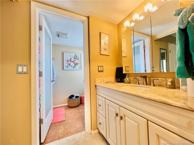 a en suite bathroom with a granite countertop sink and a mirror