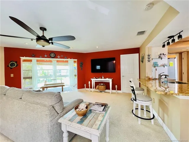 a living room with furniture a floor to ceiling window and a flat screen tv