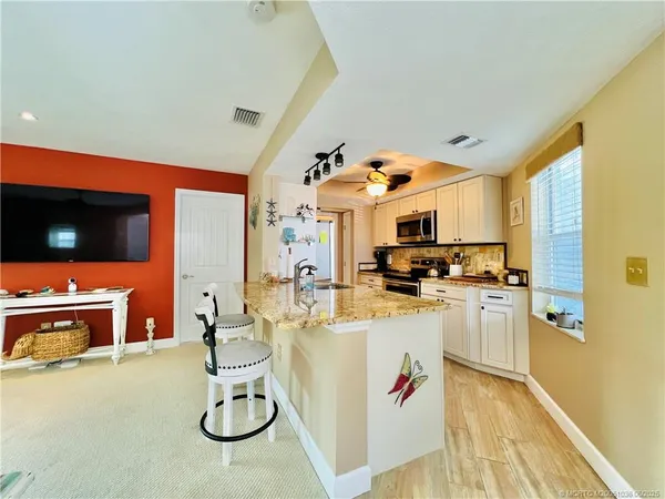 a kitchen with stainless steel appliances granite countertop a sink and a refrigerator