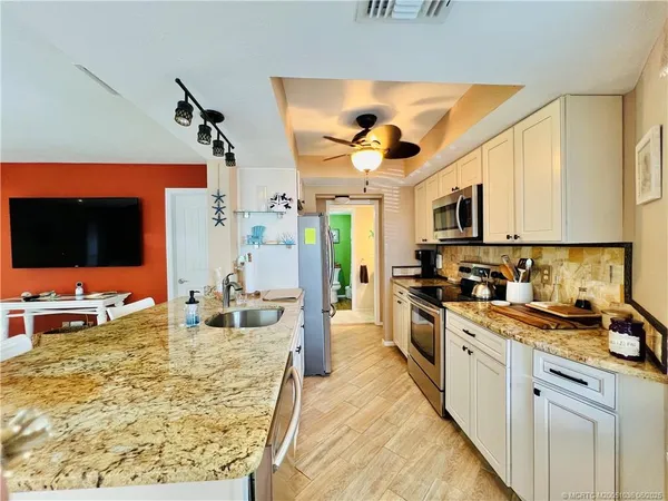a kitchen with stainless steel appliances kitchen island granite countertop a sink and cabinets