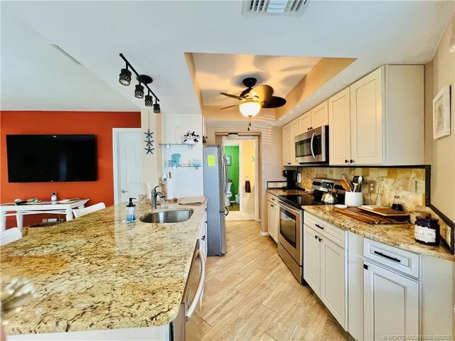 a kitchen with stainless steel appliances kitchen island granite countertop a sink and cabinets