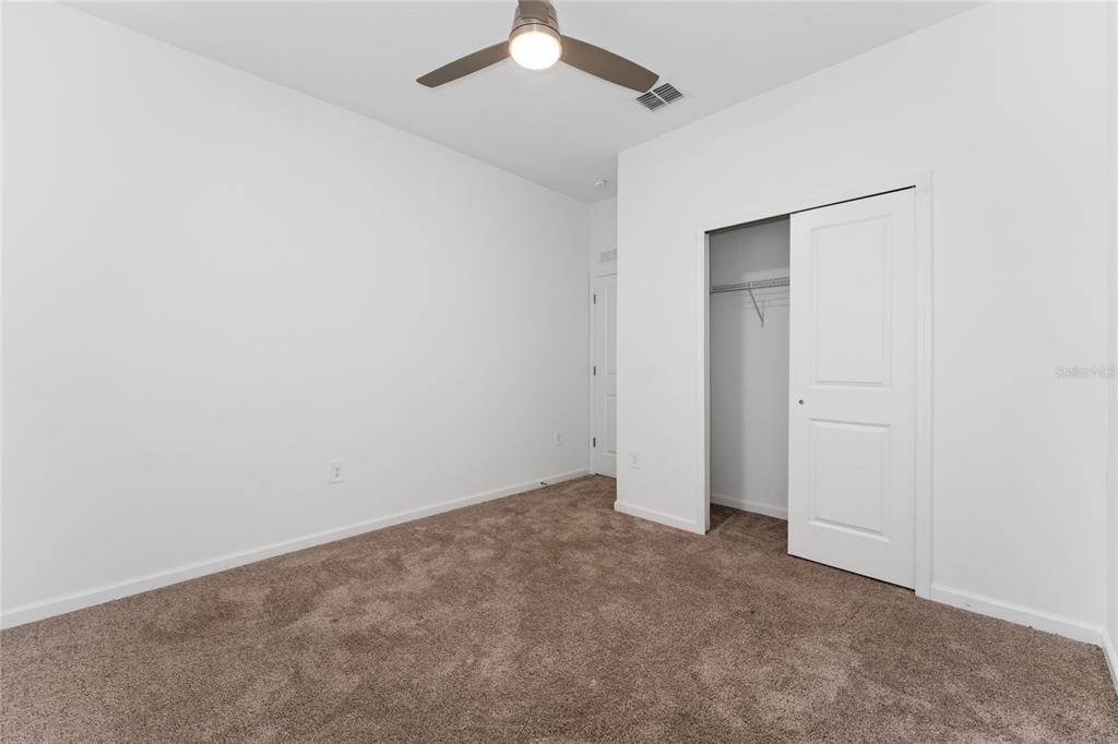 566 Hatteras Road Davenport, FL 33837 - Photo 19 of 28 an empty room with a ceiling fan and a window