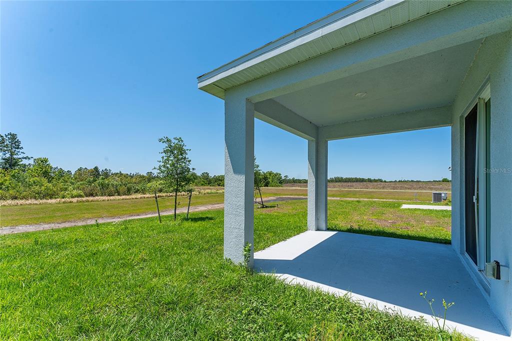 566 Hatteras Road Davenport, FL 33837 - Photo 28 of 28 a view of a backyard with table and chairs under an umbrella