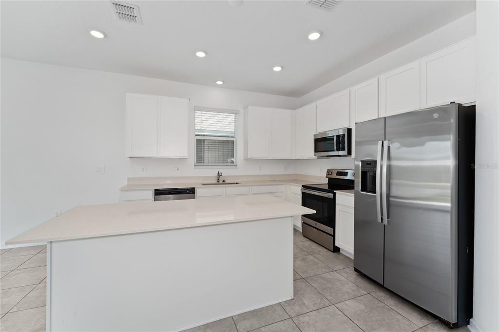 566 Hatteras Road Davenport, FL 33837 - Photo 8 of 28 a kitchen with a refrigerator sink and microwave