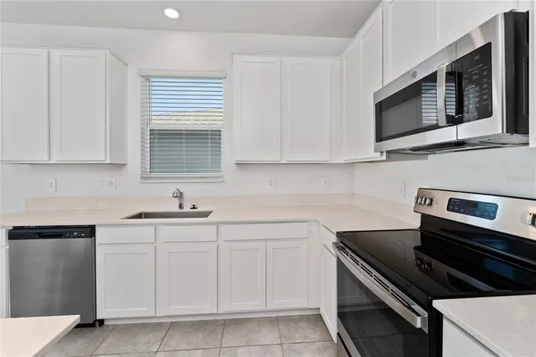 a kitchen with cabinets stainless steel appliances and a sink