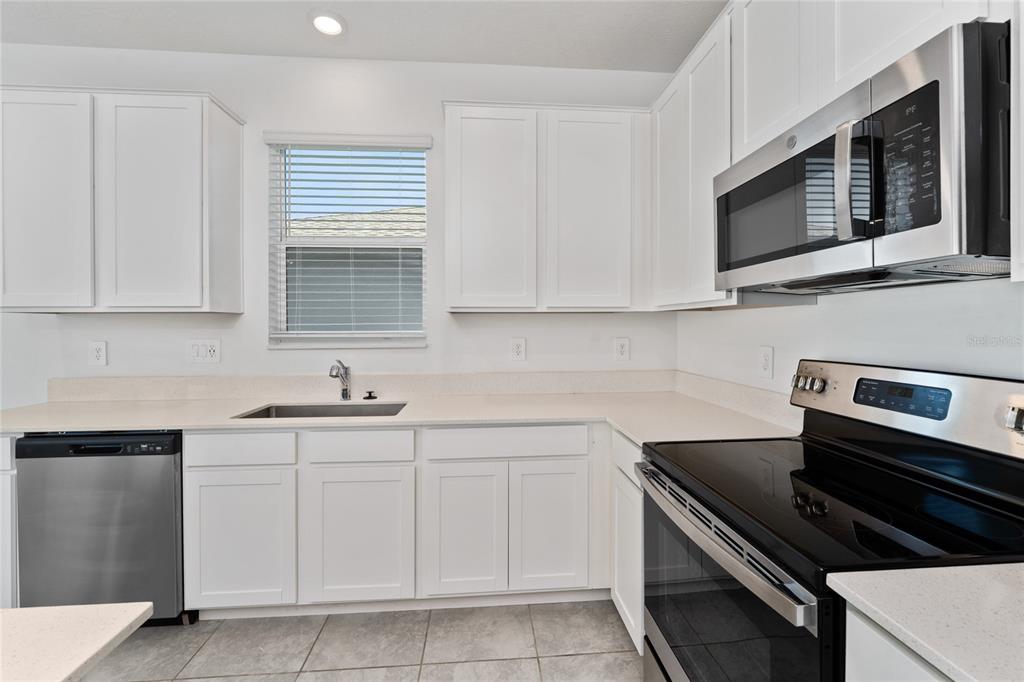 566 Hatteras Road Davenport, FL 33837 - Photo 10 of 28 a kitchen with cabinets stainless steel appliances and a sink