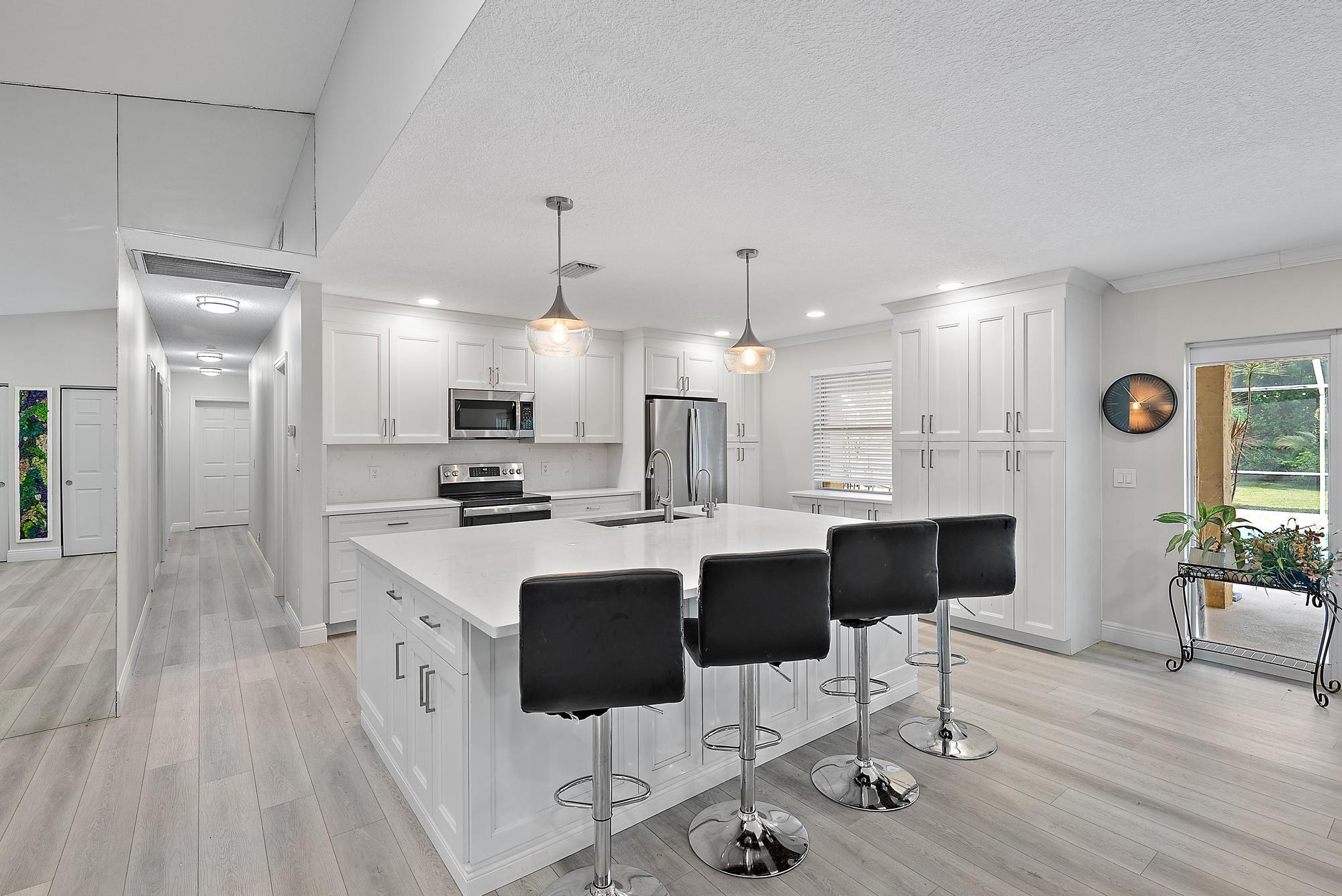 a kitchen with stainless steel appliances kitchen island granite countertop a table chairs sink and cabinets