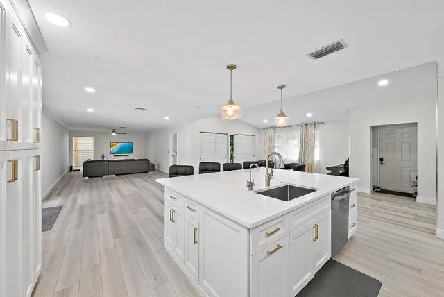 a view of a kitchen counter top space with sink and wooden floor
