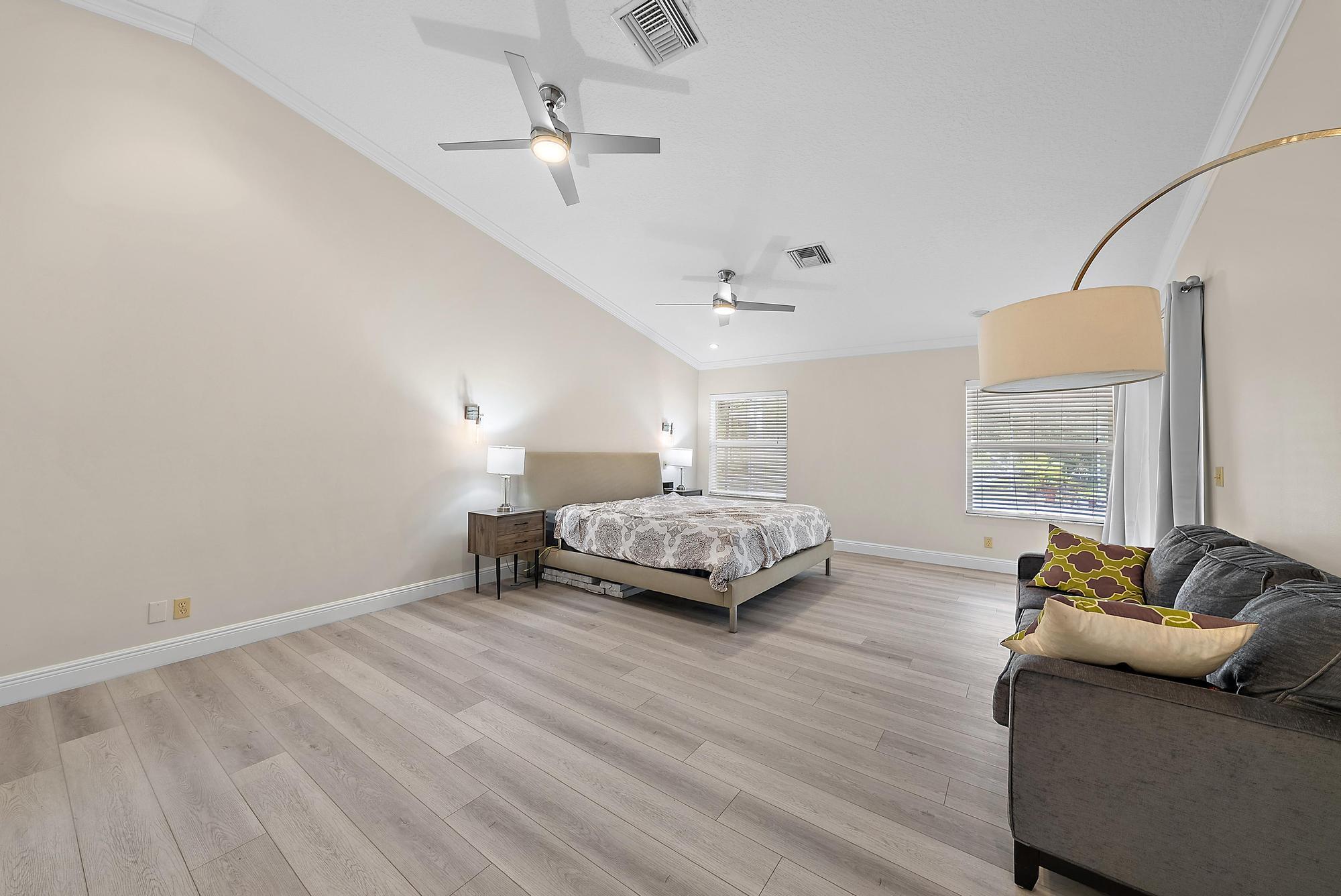 16338 Alexander Run Jupiter, FL 33478 - Photo 11 of 32 a bedroom with a bed and wooden floor