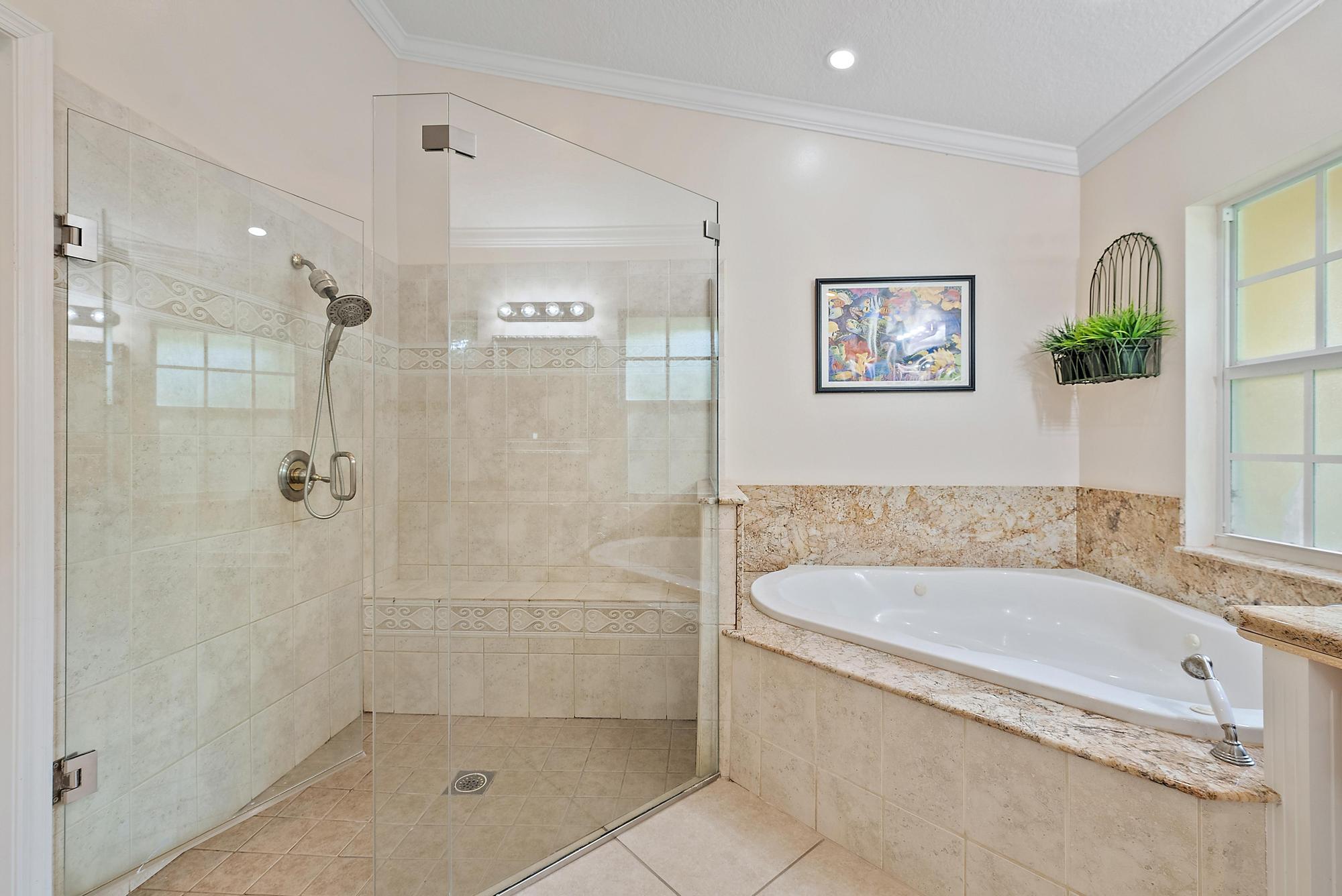 16338 Alexander Run Jupiter, FL 33478 - Photo 15 of 32 a bathroom with a bathtub and shower