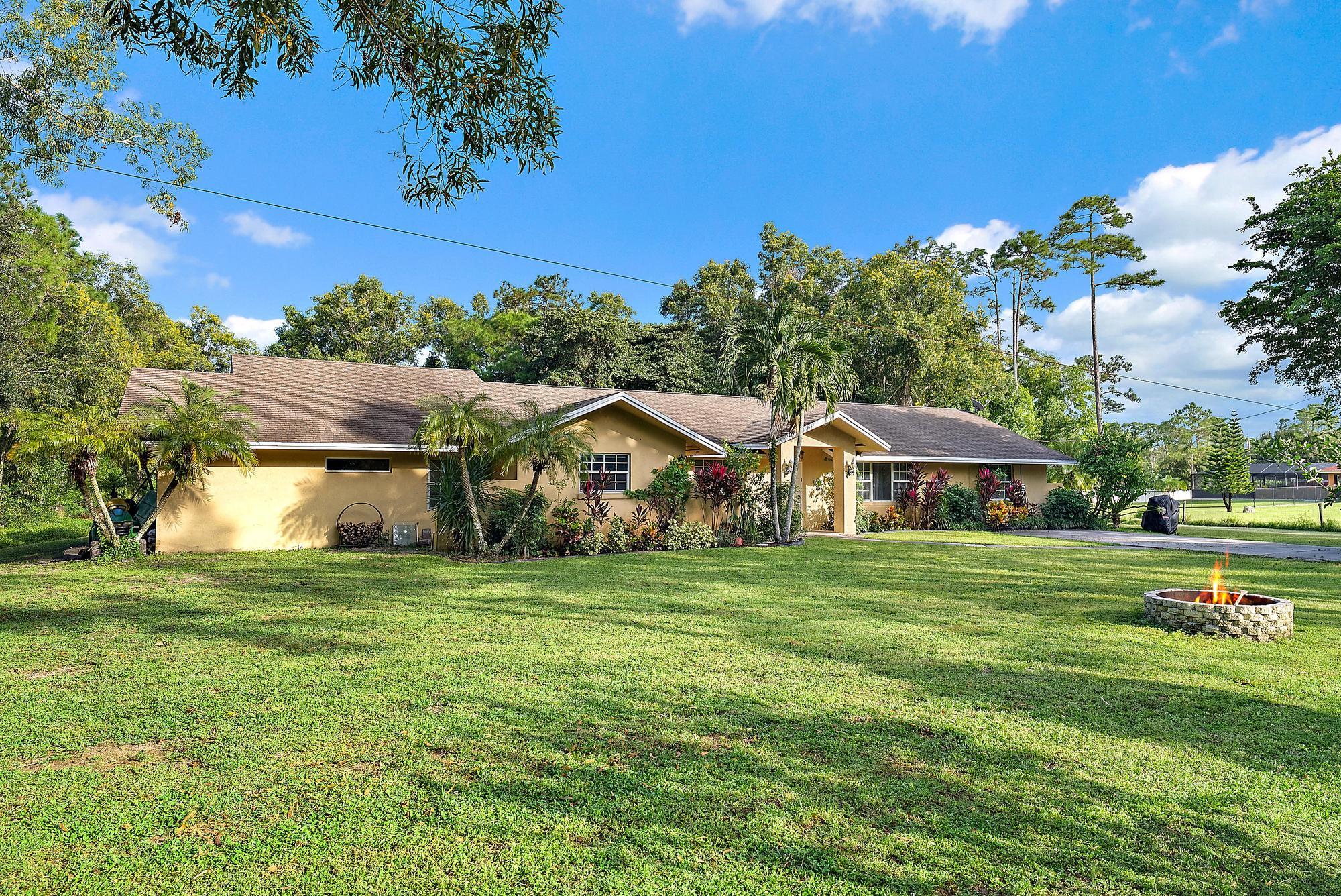 16338 Alexander Run Jupiter, FL 33478 - Photo 24 of 32 a front view of a house with a garden