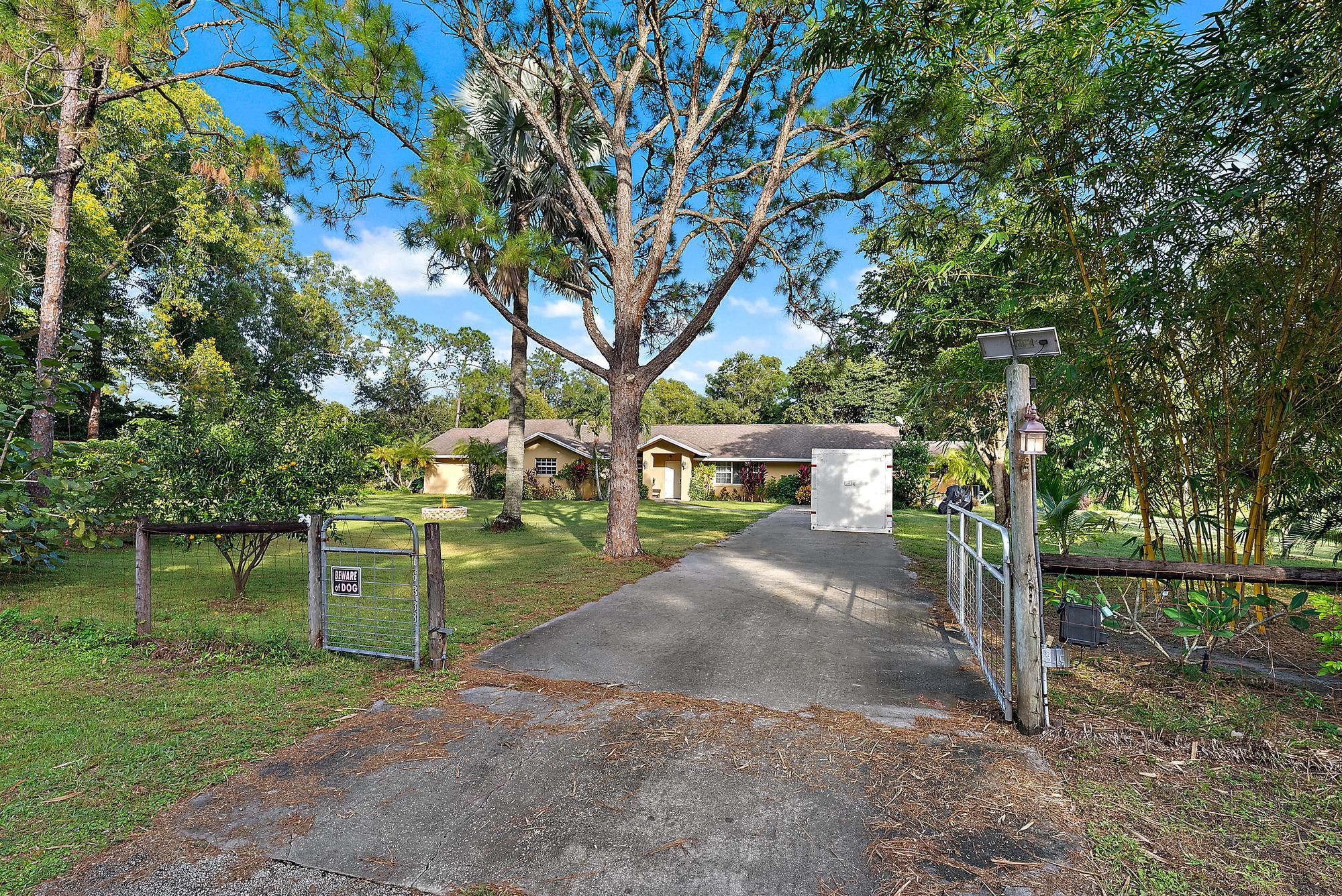 16338 Alexander Run Jupiter, FL 33478 - Photo 27 of 32 a front view of a house with a yard and garage