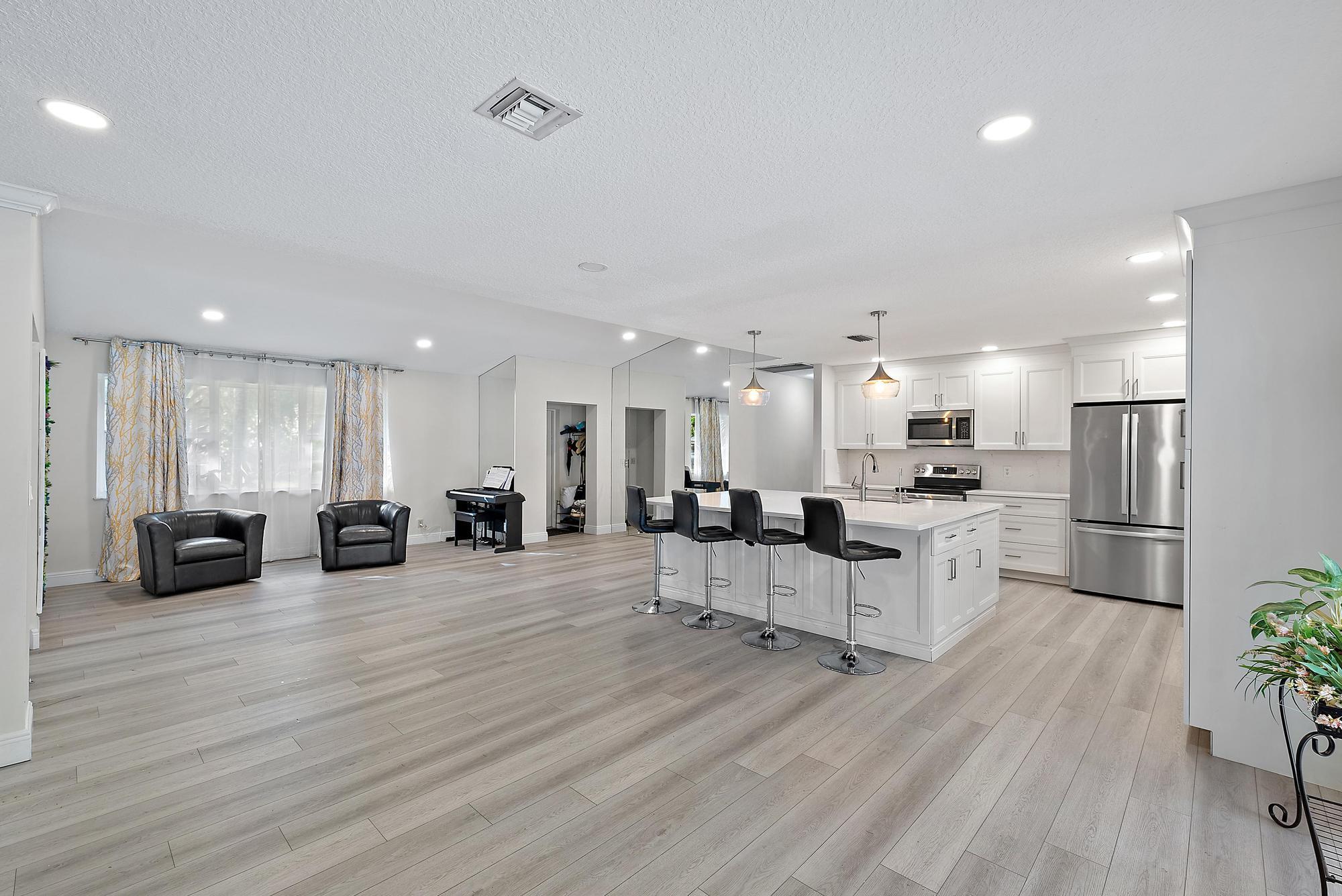 16338 Alexander Run Jupiter, FL 33478 - Photo 4 of 32 a large white kitchen with lots of counter space a sink and appliances
