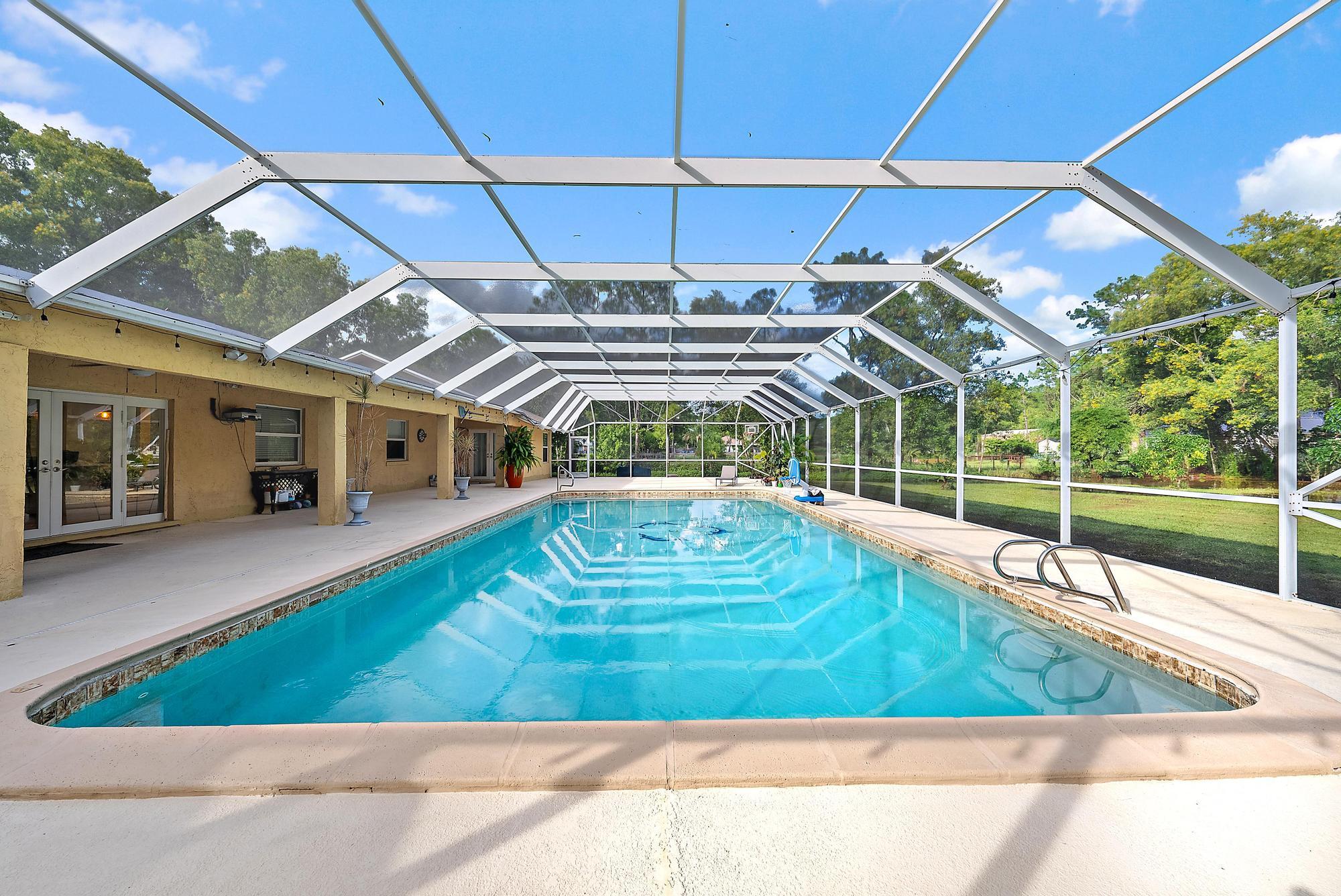 16338 Alexander Run Jupiter, FL 33478 - Photo 6 of 32 a view of a backyard with a swimming pool
