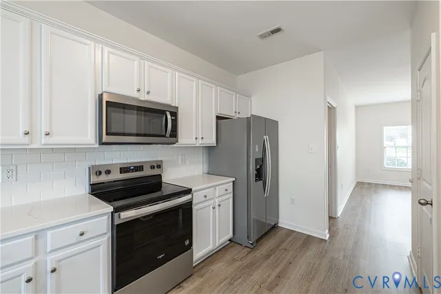 a kitchen with stainless steel appliances a stove microwave and a sink