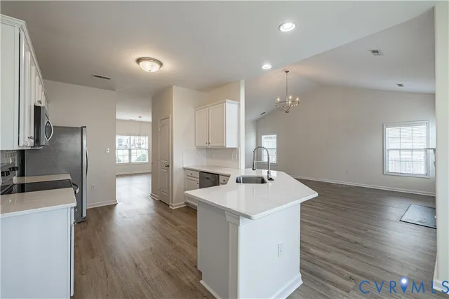 a kitchen with a sink a counter top space and stainless steel appliances