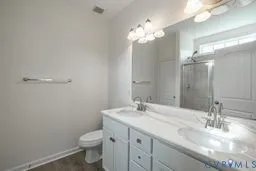 a bathroom with a granite countertop sink a toilet and a mirror