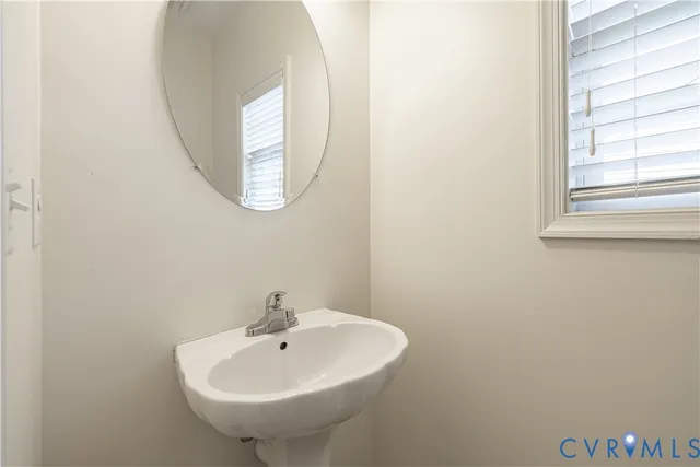 a bathroom with a sink a mirror and a window