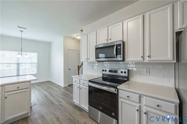 a kitchen with stainless steel appliances a stove microwave and sink