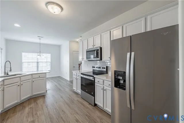 a kitchen with stainless steel appliances a refrigerator sink and microwave
