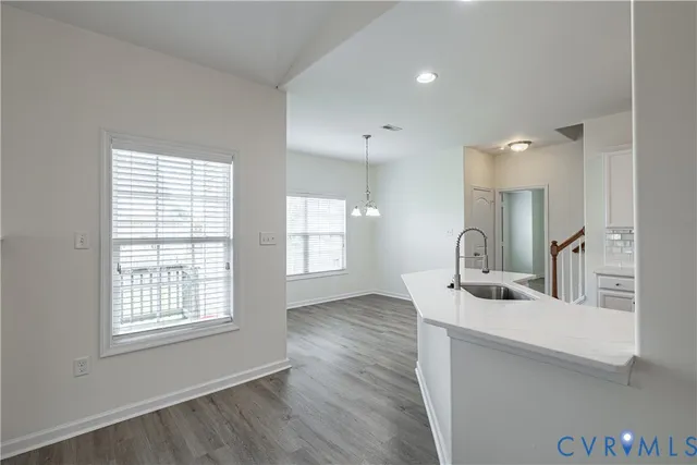 a kitchen with stainless steel appliances granite countertop a sink a stove and a wooden floor