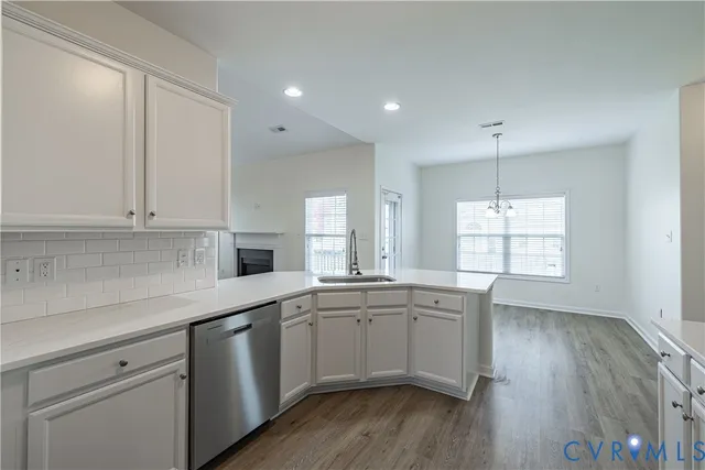 a kitchen with a sink cabinets wooden floor and a window