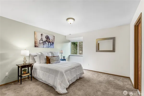 a bedroom with a large bed and a painting on the wall