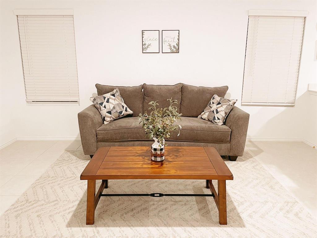 136 Honeysuckle Street Princeton, TX 75407 - Photo 4 of 13 a living room with a couch and a table