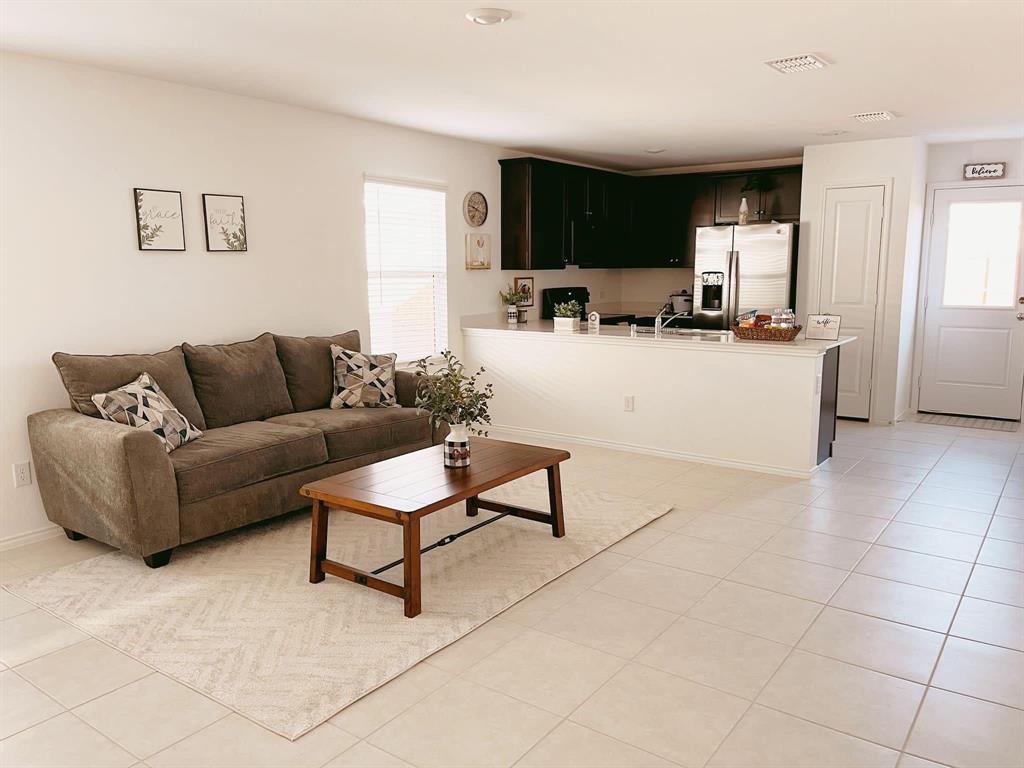 136 Honeysuckle Street Princeton, TX 75407 - Photo 5 of 13 a living room with furniture and a dining table with kitchen view