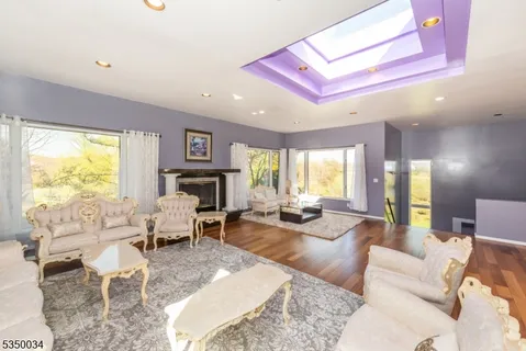 a living room with fireplace furniture and a large window