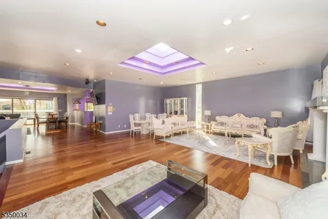 a living room with furniture kitchen view and a large window