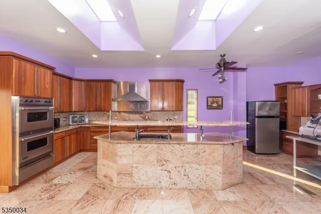 a kitchen with stainless steel appliances kitchen island granite countertop a sink and cabinets