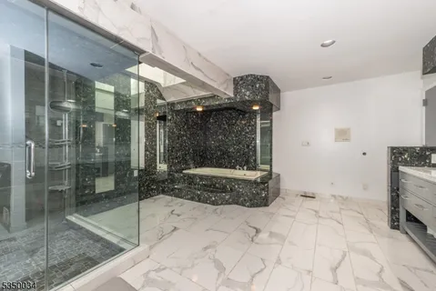 a bathroom with a granite countertop sink mirror and shower