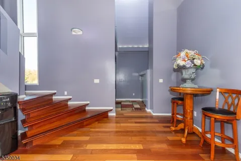 a room with chandelier fan and wooden floor