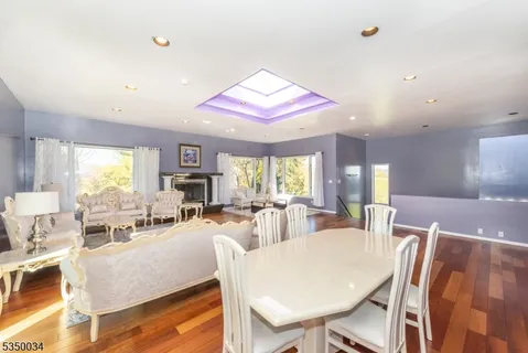 a living room with furniture a large window and a dining table
