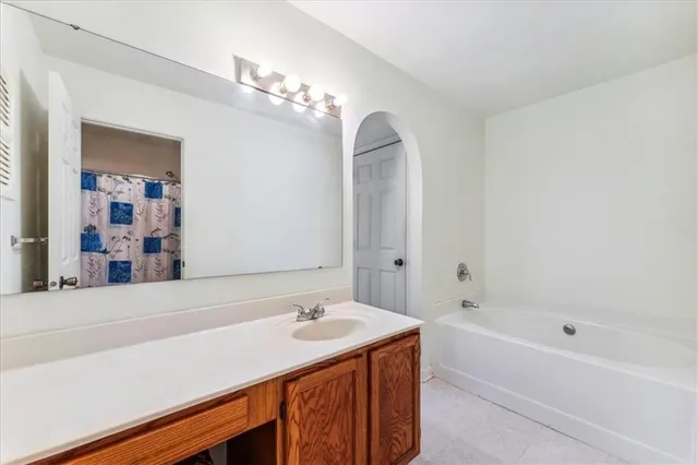 a bathroom with a sink a large mirror and a bathtub