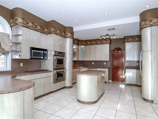 a kitchen with stainless steel appliances granite countertop a refrigerator and a stove top oven