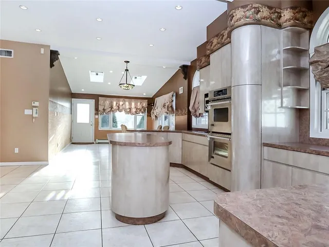 a kitchen with stainless steel appliances granite countertop a refrigerator a stove and a sink