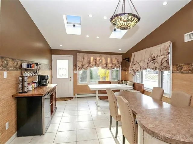 a kitchen with stainless steel appliances granite countertop a stove top oven a dining table and chairs with wooden floor