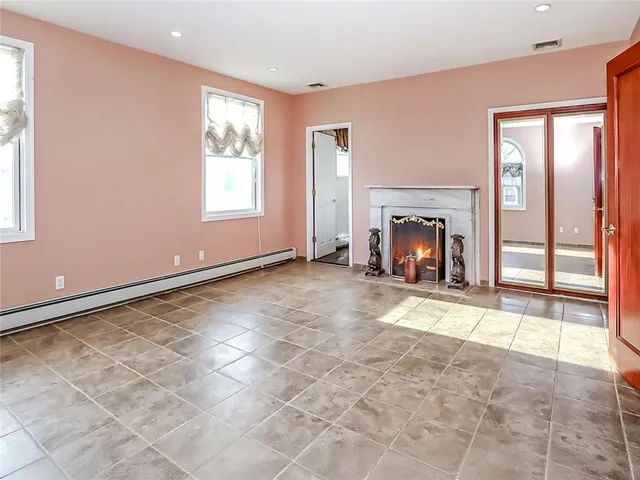 an empty room with fireplace and windows
