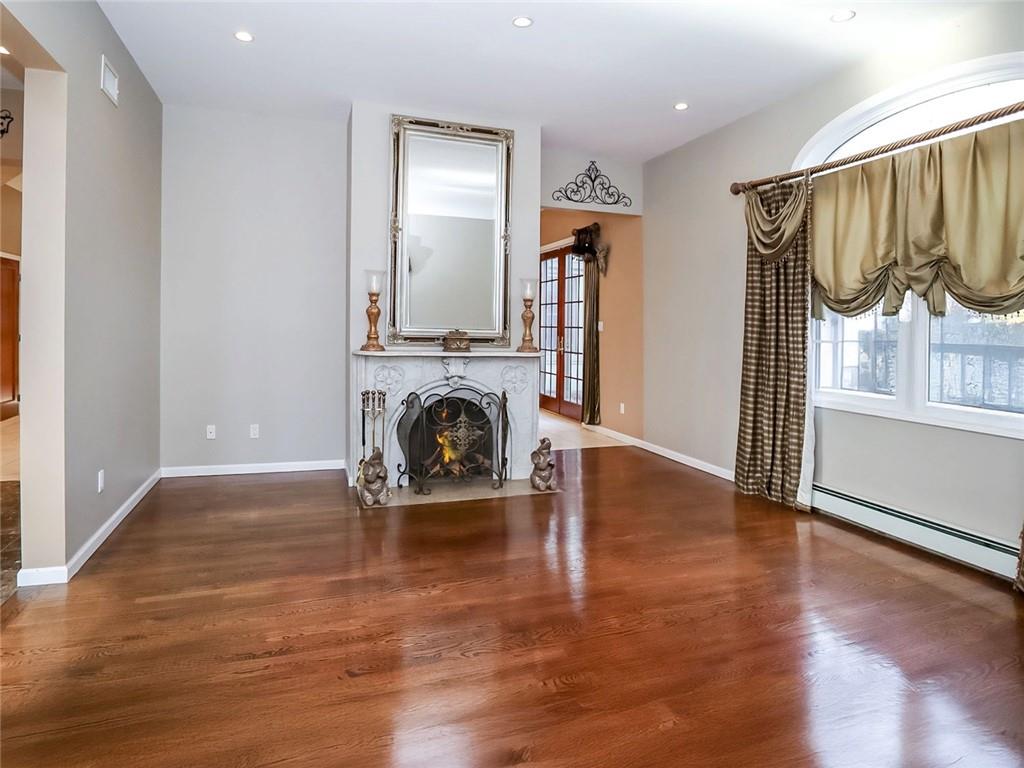 39 Hasbrouk Road Staten Island, NY 10304 - Photo 8 of 50 an empty room with wooden floor fireplace and a window