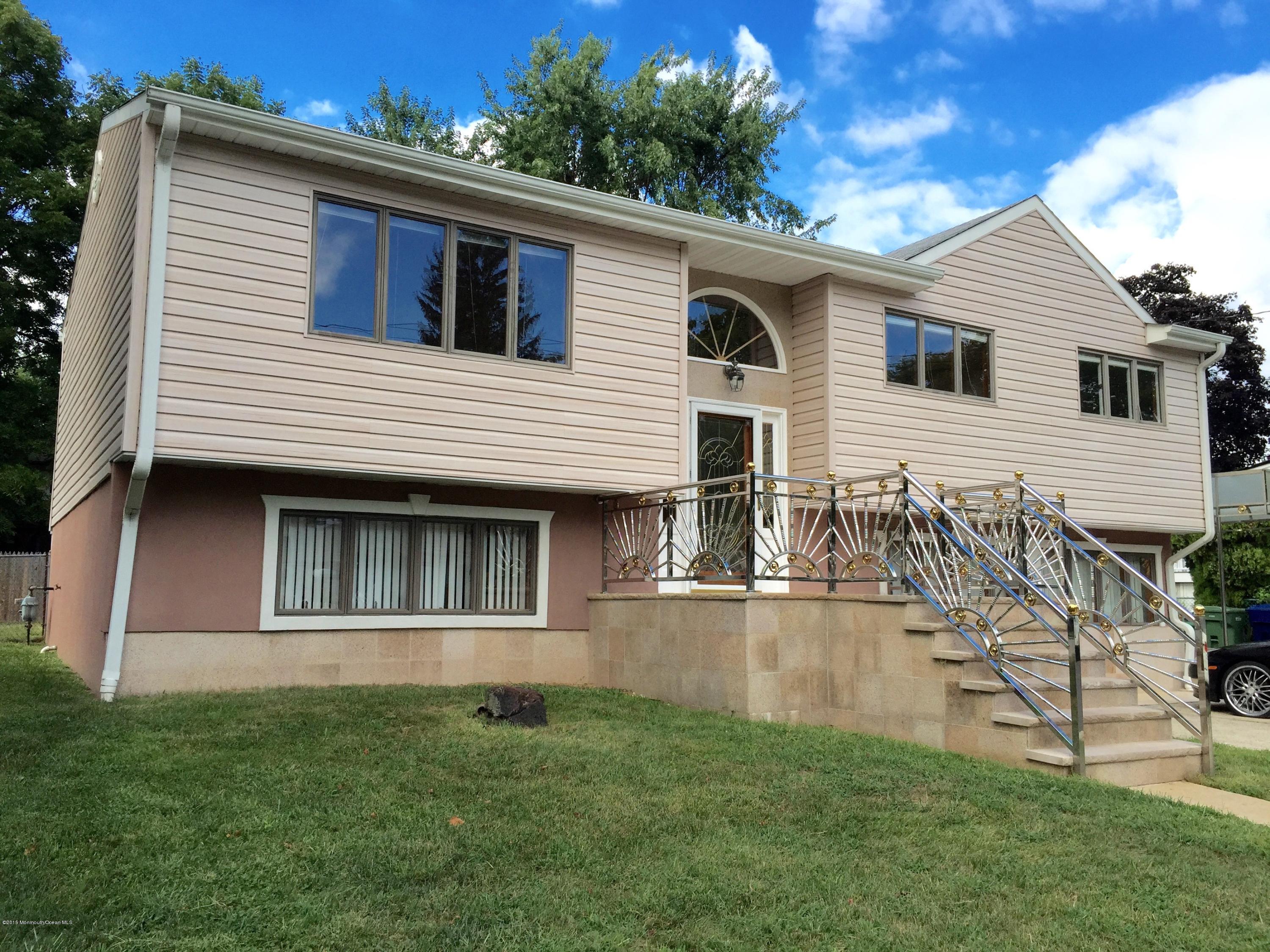 a view of a white house with a big yard potted plants and large tree