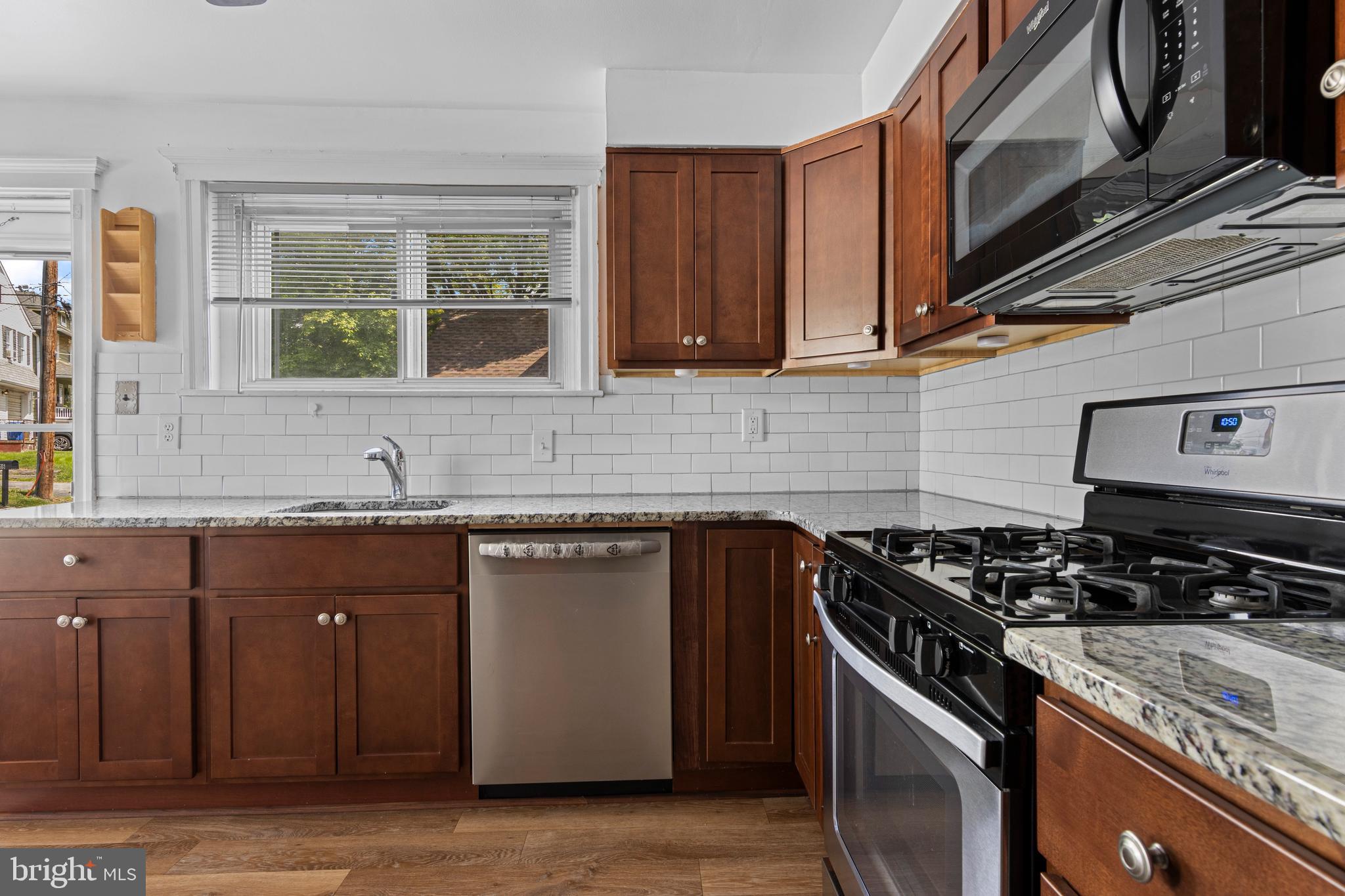 153 Conestoga Road Wayne, PA 19087 - Photo 4 of 13 a kitchen with granite countertop a sink a stove and cabinets