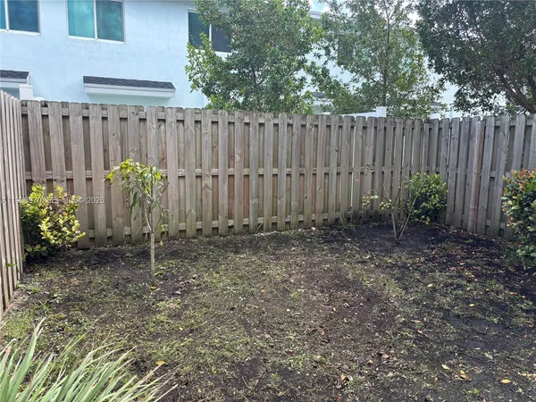a front view of a garden with wooden fence