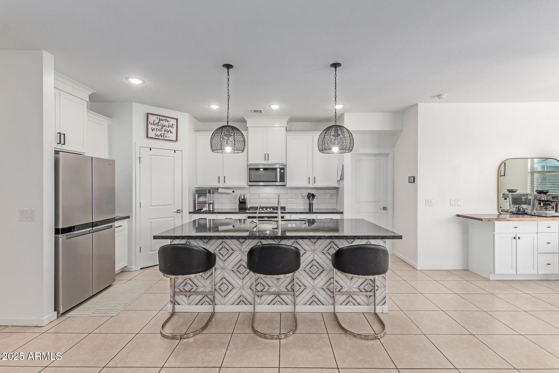 37287 North Azteca Road San Tan Valley, AZ 85140 - Photo 9 of 37 a kitchen with stainless steel appliances granite countertop a sink a stove a refrigerator cabinets a dining table and chairs