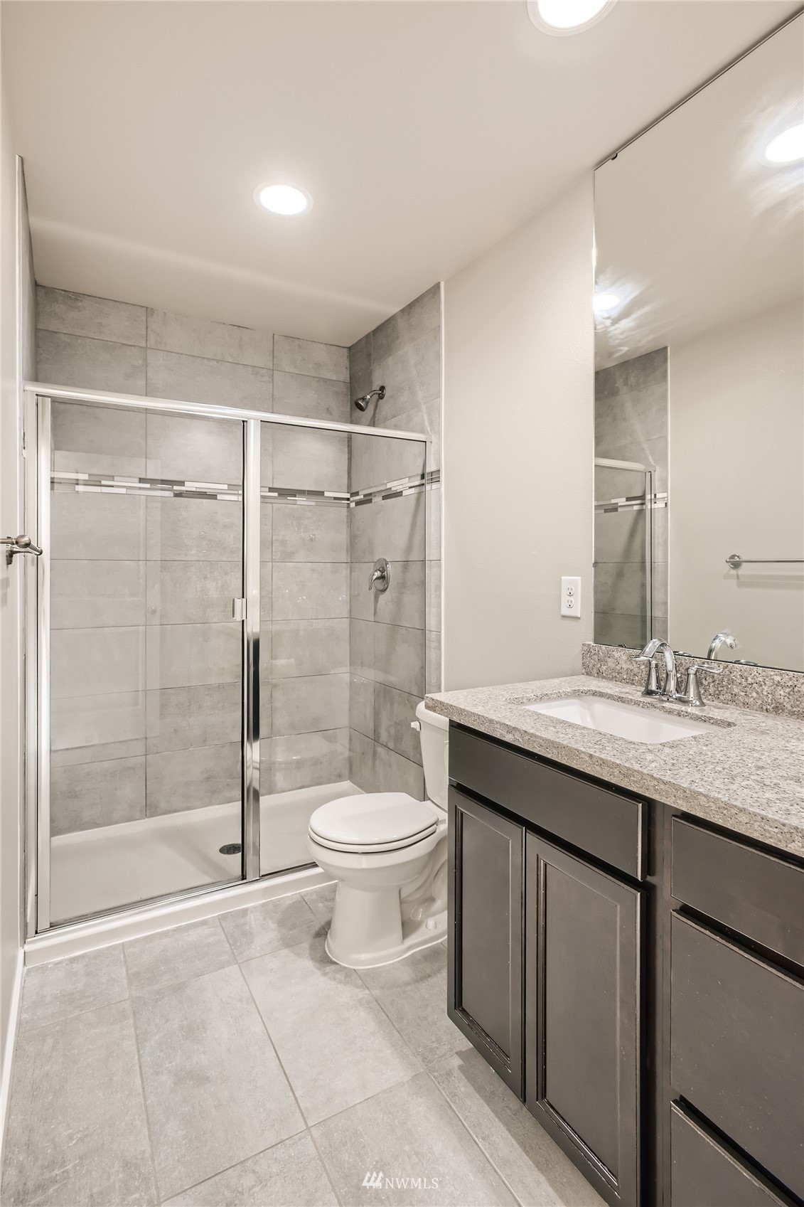 729 112th Street Southwest, Unit G1 Everett, WA 98204 - Photo 17 of 27 a bathroom with a granite countertop sink a toilet a mirror and shower